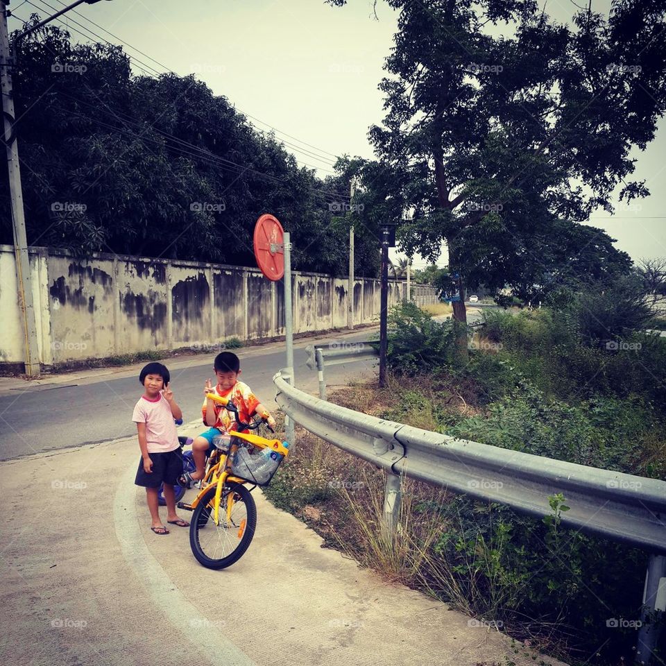 Asian children riding bicycle.