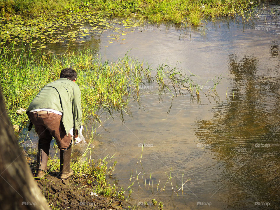 It is possible to see a man in boots looking something in the lake for a possible capture.