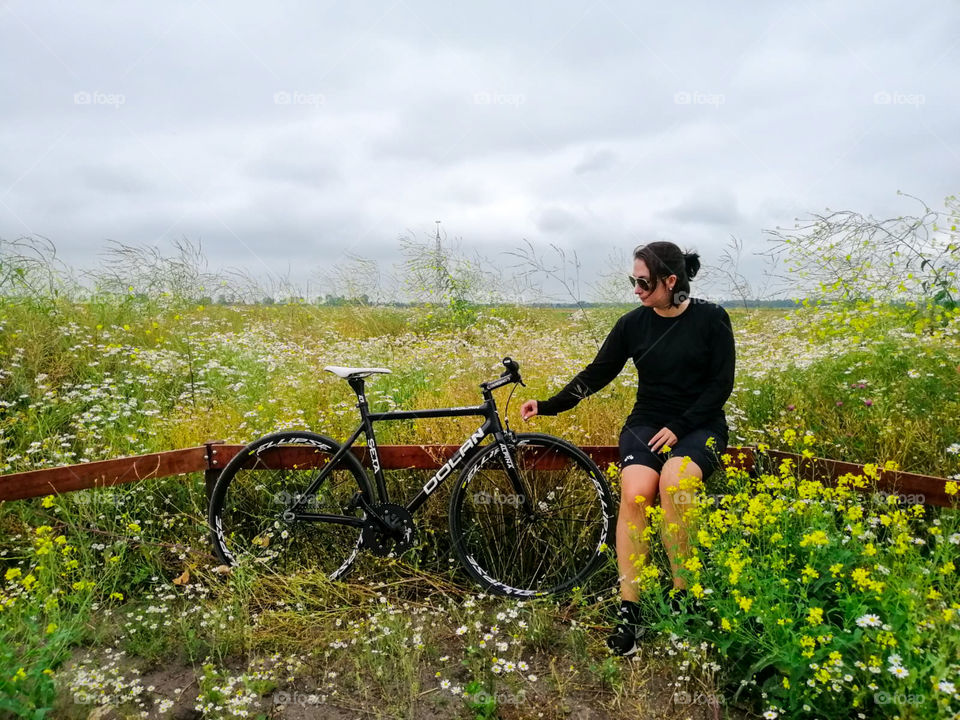 Girl and her bicycle surrounded by flowers