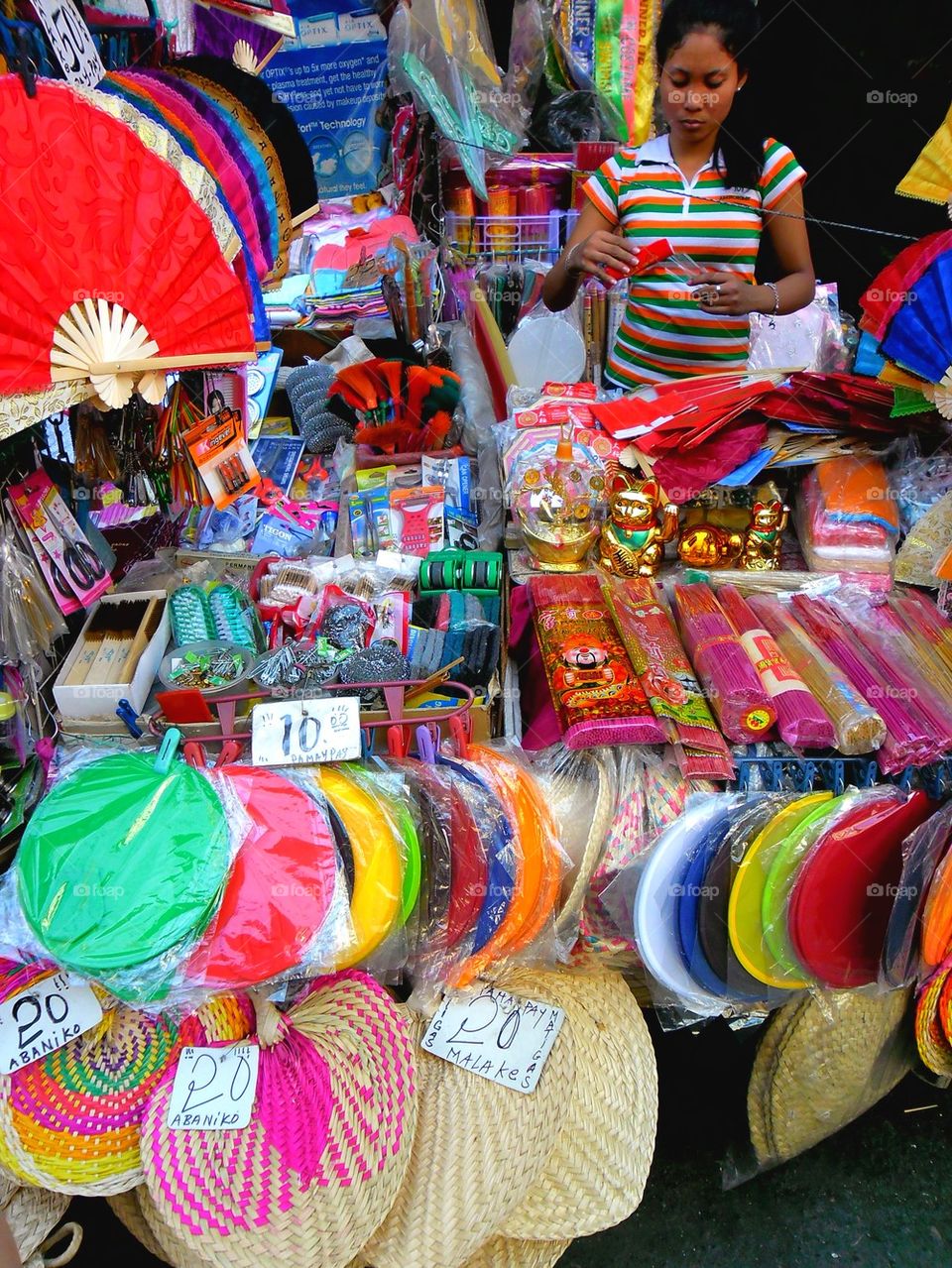 asian street vendor selling different kinds of colorful fans in quiapo, manila, philippines in asia