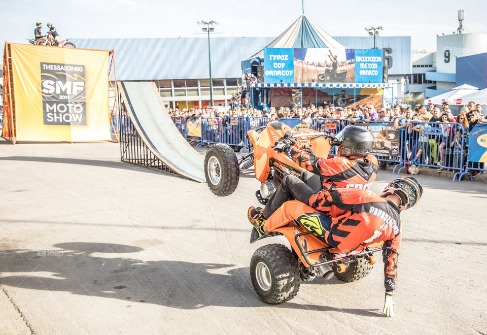 Doing Acrobatics With Quad Bike Terrain Vehicle In Front Of Crowd
