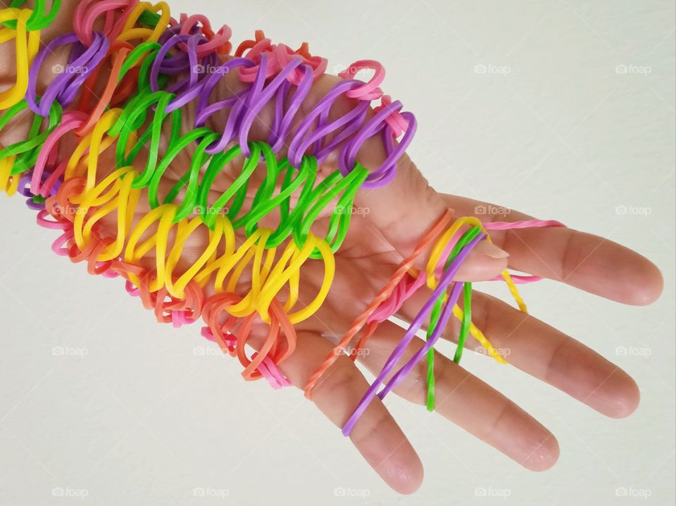 Colorful rubber bands around the hand.