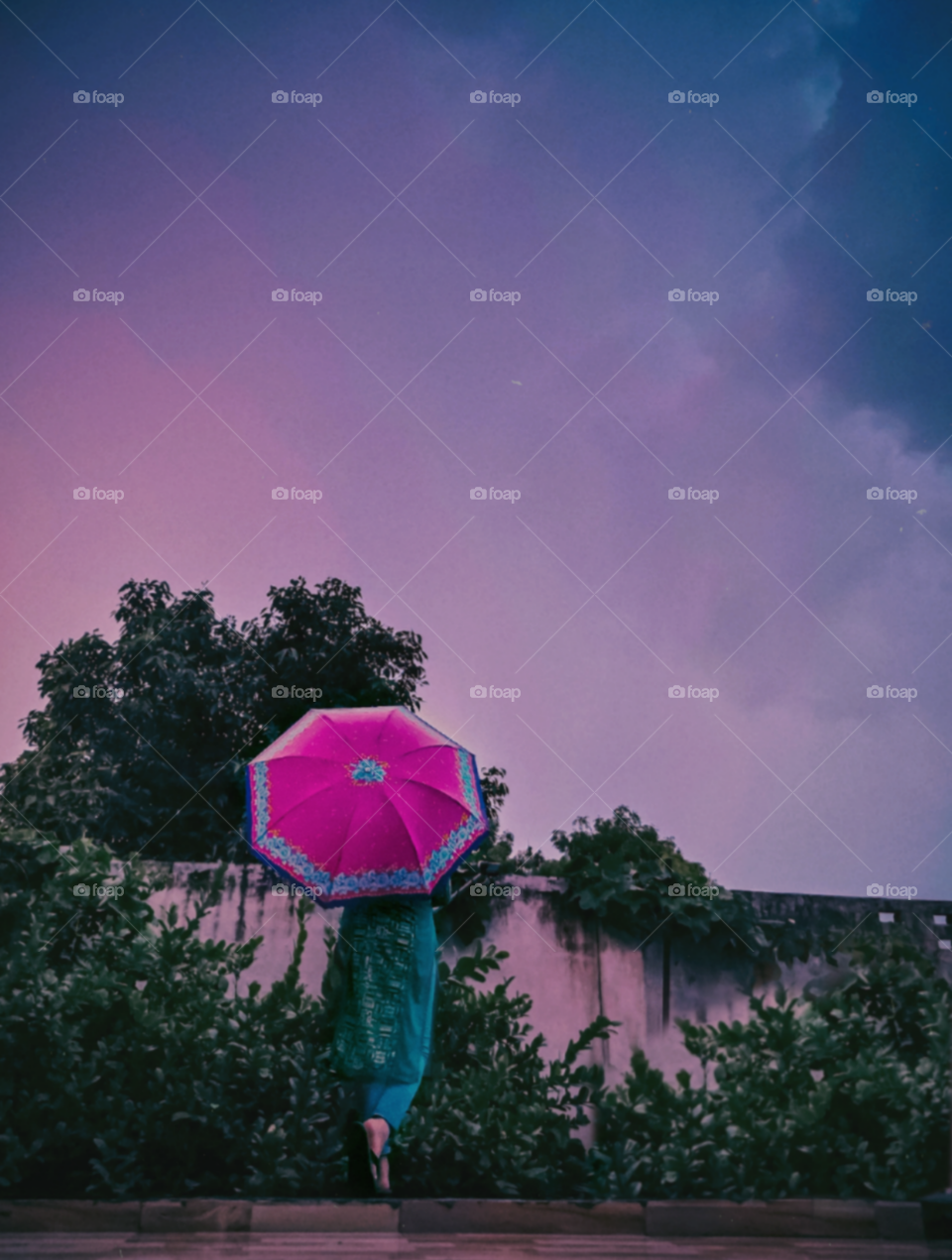 a lady enjoying the weather under the umbrella.