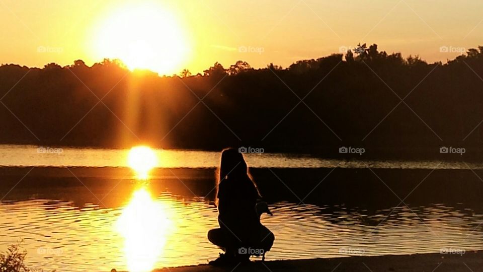 Child's silhoette with duck at dusk