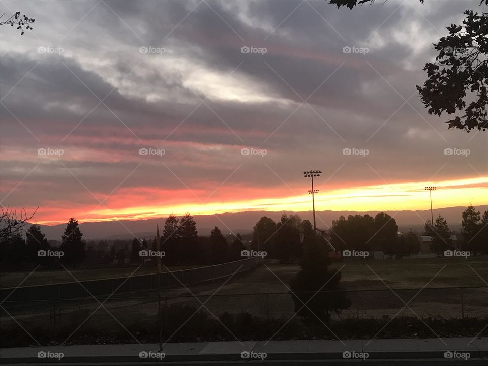 Sweeping clouds across orange sky 