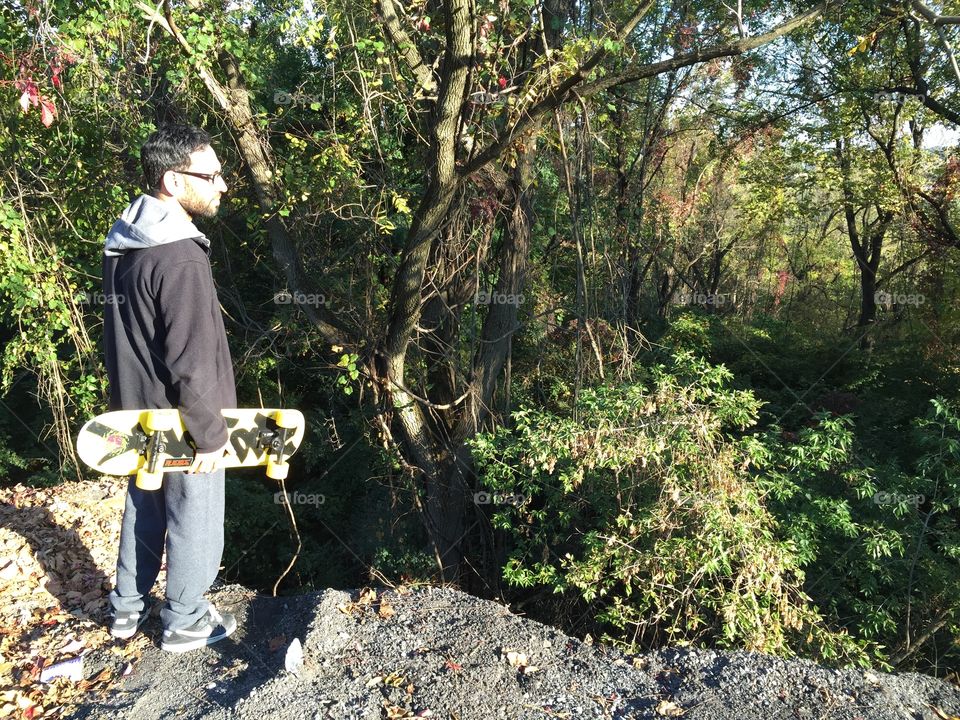 Forest peak . Skater looking over a forest from a cliff, Easton, Pa 
