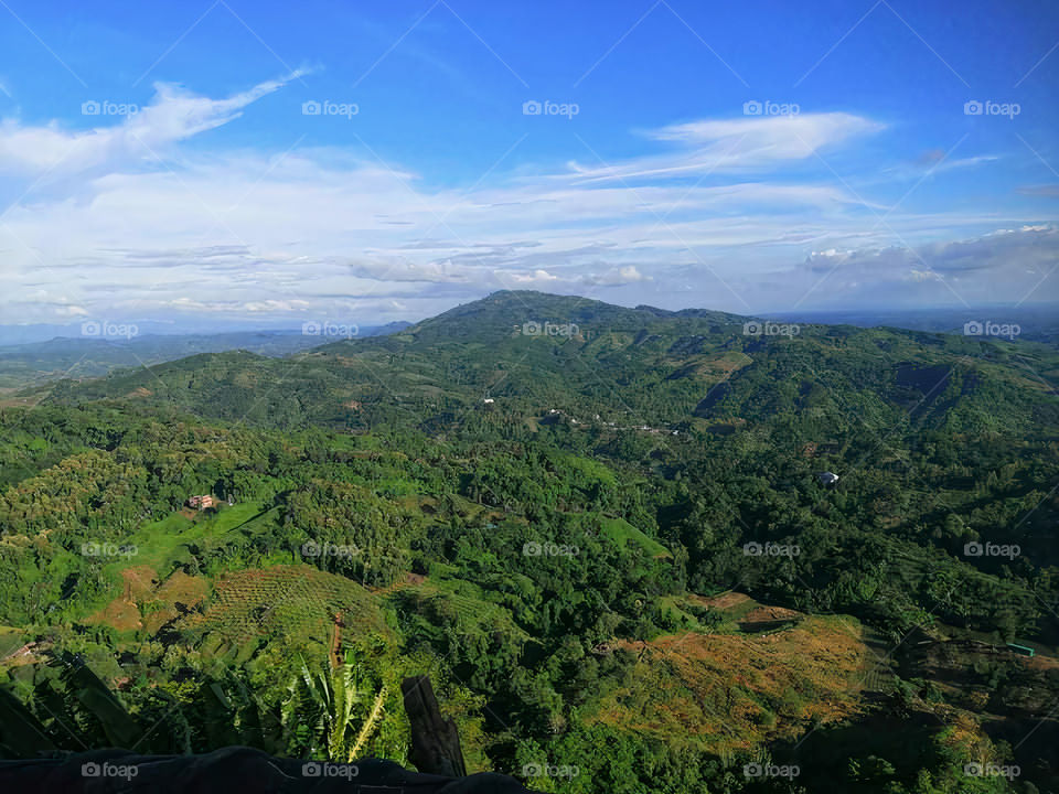 The blue sky in the distance can be seen through the gap of the mountain, it seems that in a natural and heavenly place, standing on the hill, I want to dream of touching the sky.