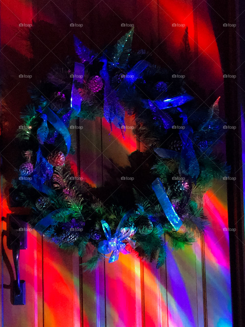 The artificial light from a rotating projection strobe lights up our front entranceway and our peacock themed Christmas wreath in an array of rainbow colours.