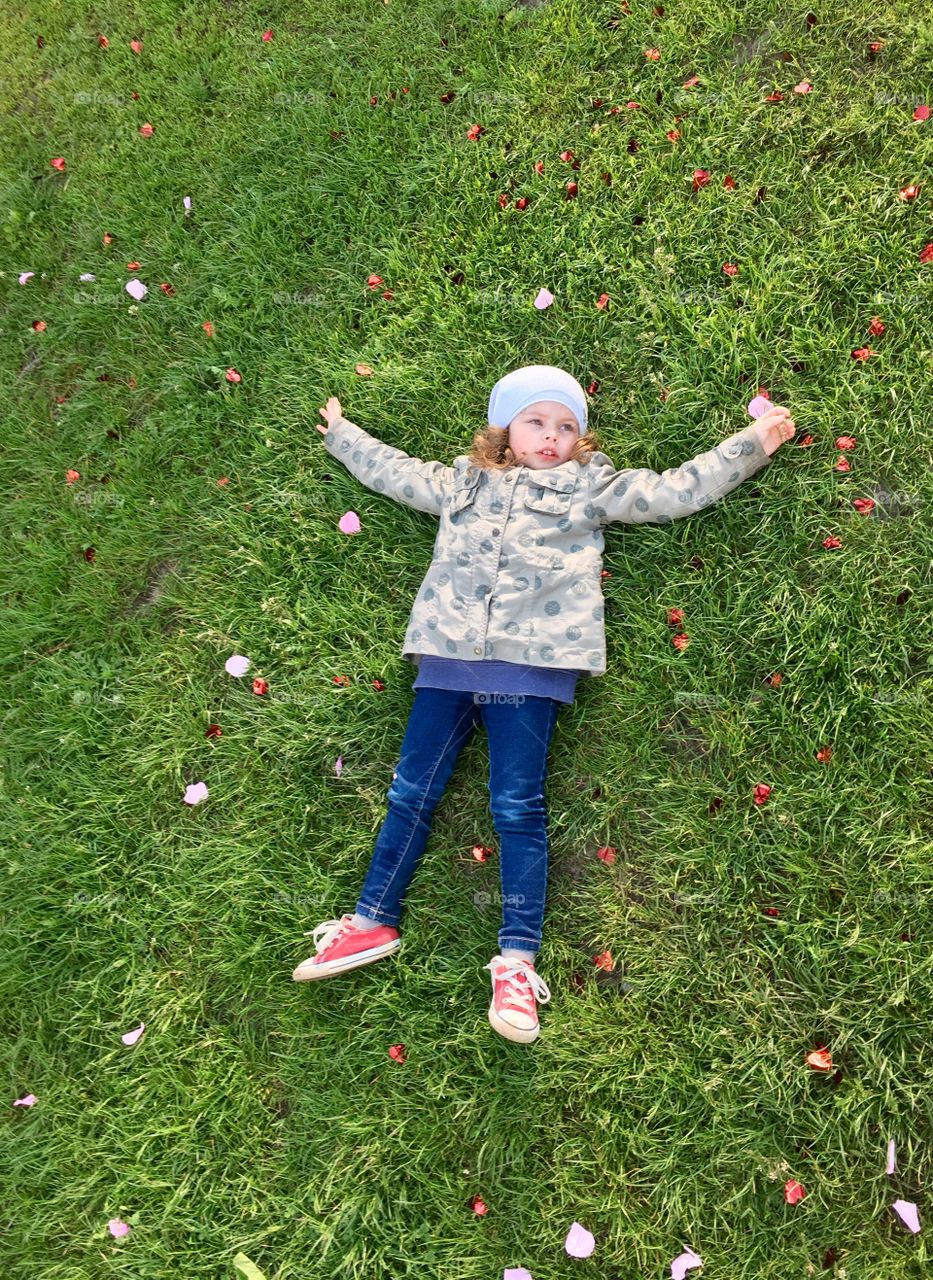 Funny cute girl lying on the grass 