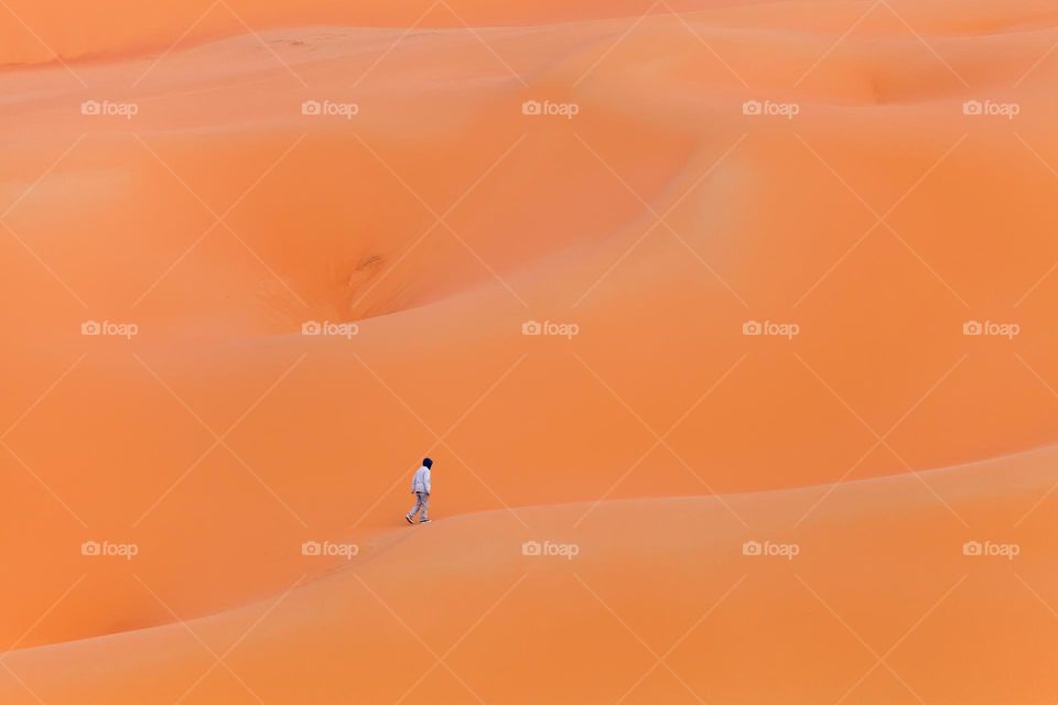 Boy walking out in the desert sand dunes