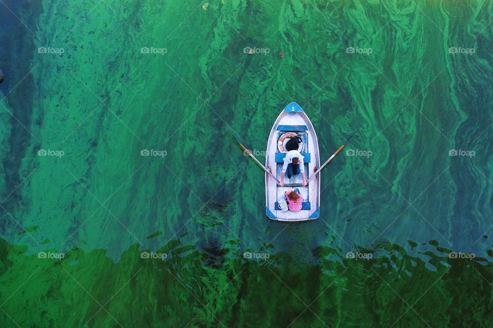 boat on the green flowering water of the Dnieper river in the city of Kiev, Ukraine