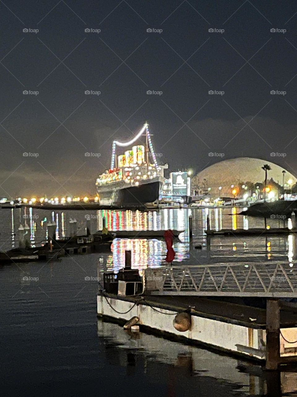 The twinkling lights from the historical Queen Mary Cruise ship docked in the port of Long Beach, California.