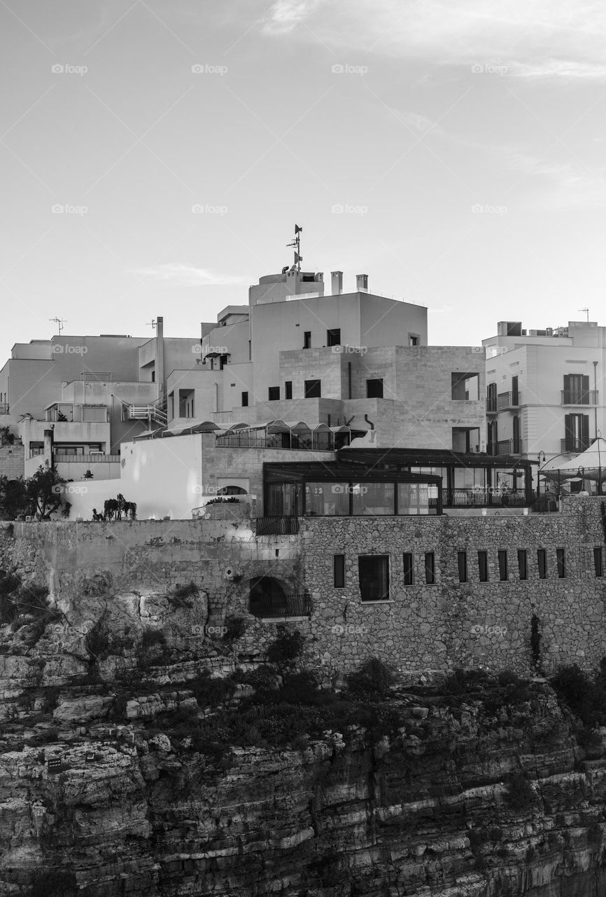 Beautiful view of square houses with square windows built on a rock on the shores of the Adriatic Sea in Polignano a Mare in Italy, close-up side view. Architecture and buildings concept.