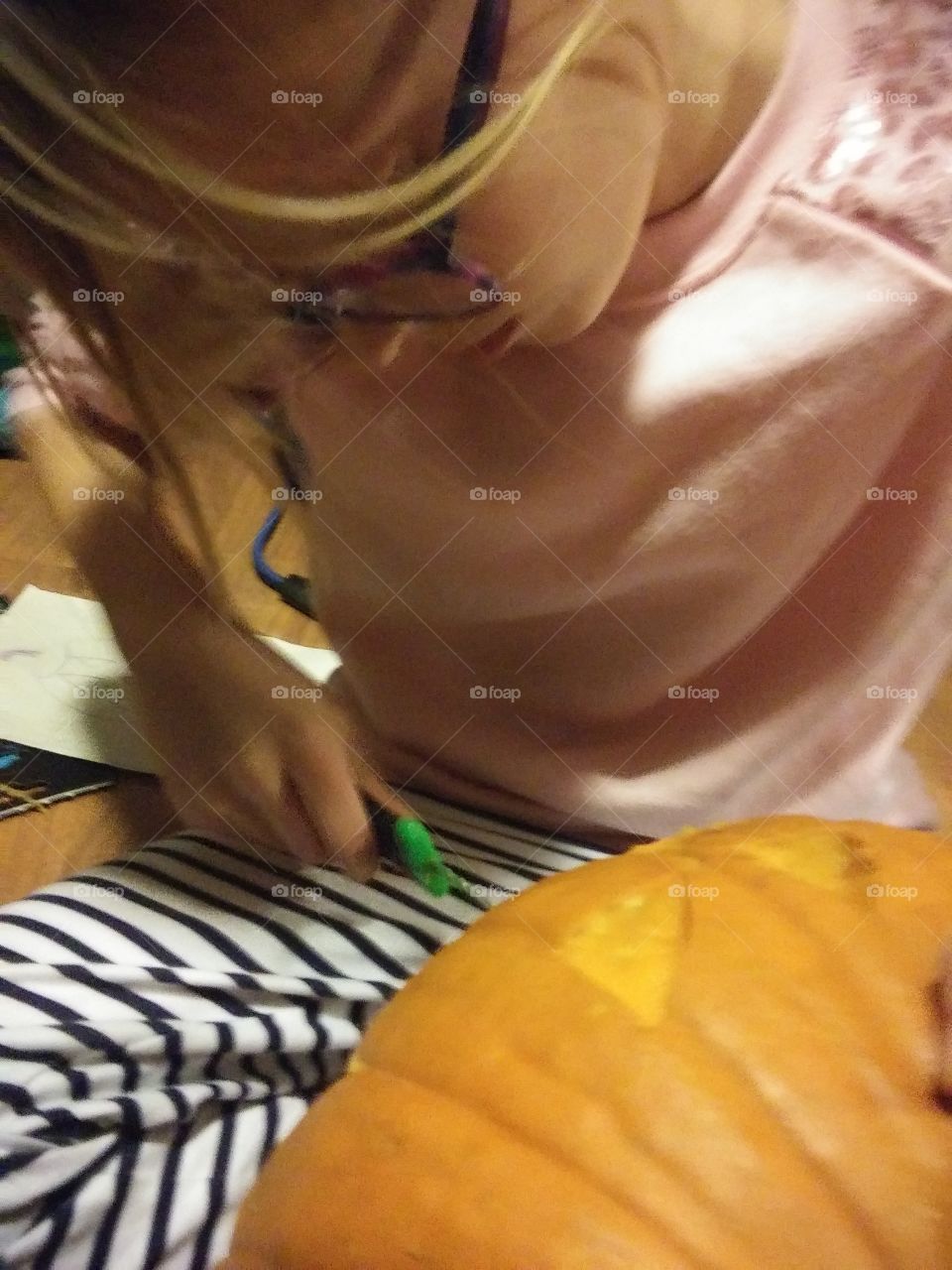 little girl carving a pumpkin