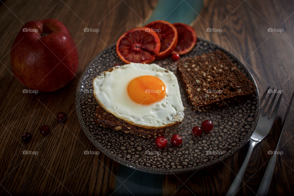 Sandwiches with fried egg orange tomato and red orange fruit 