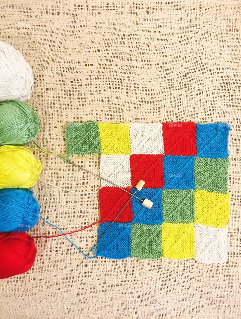 Patchwork needles. Colored squares. It will be a bright cover on a cushion 