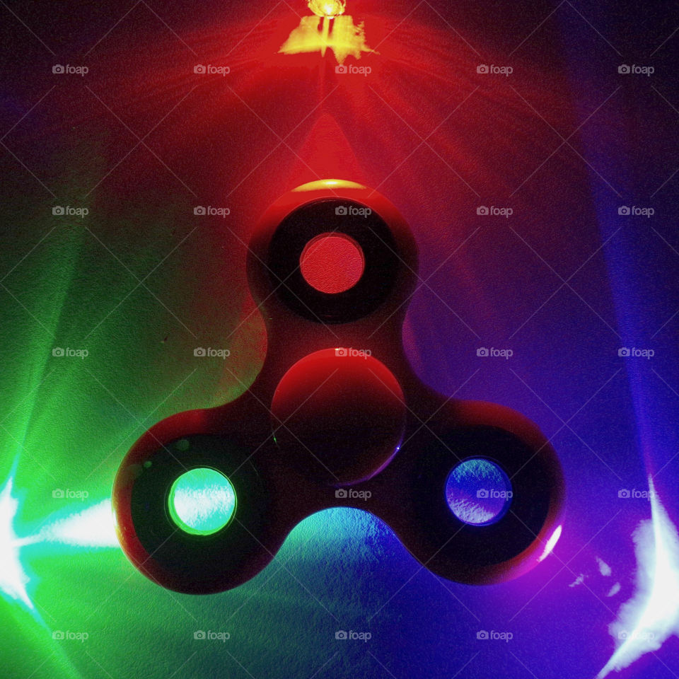 A fidget spinner lit by small LED lights