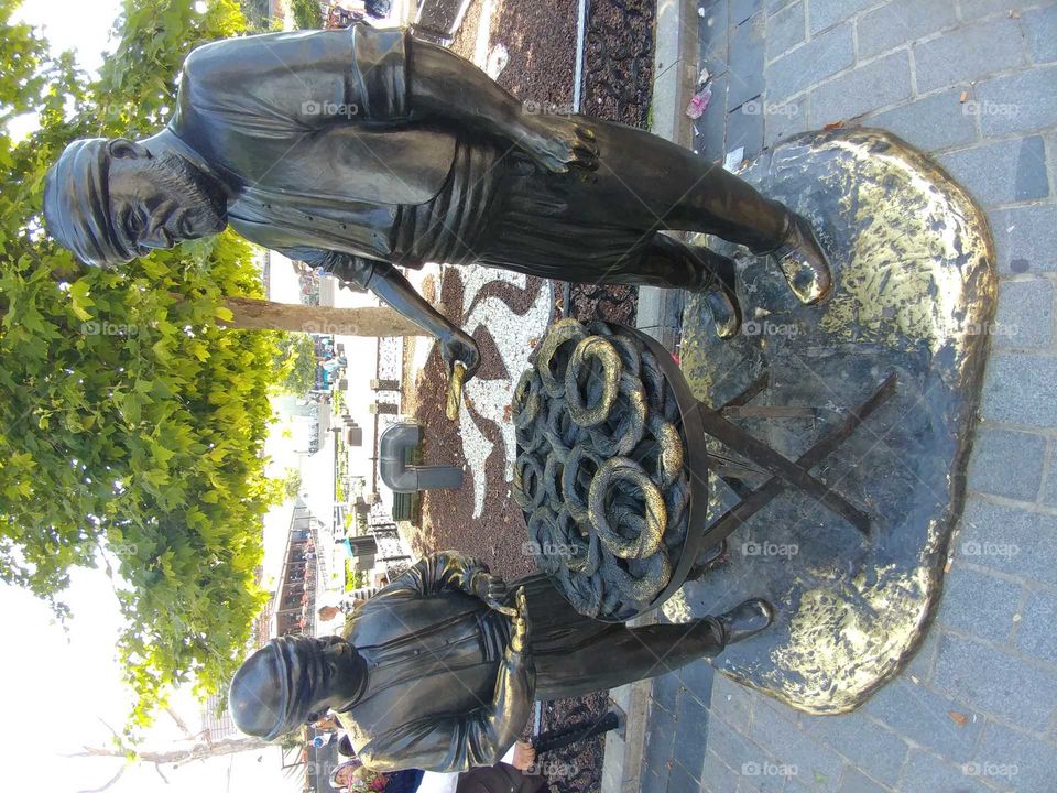 statue of man selling. traditional turkish simit to a child