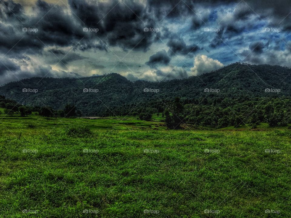 Green Field, Mountains at the back, Black Clouds !!