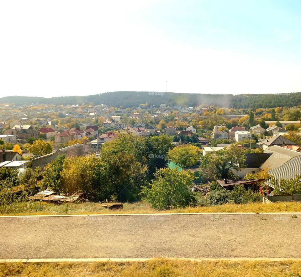 view of a small village located under the forest, with numerous multi-colored roofs and houses!