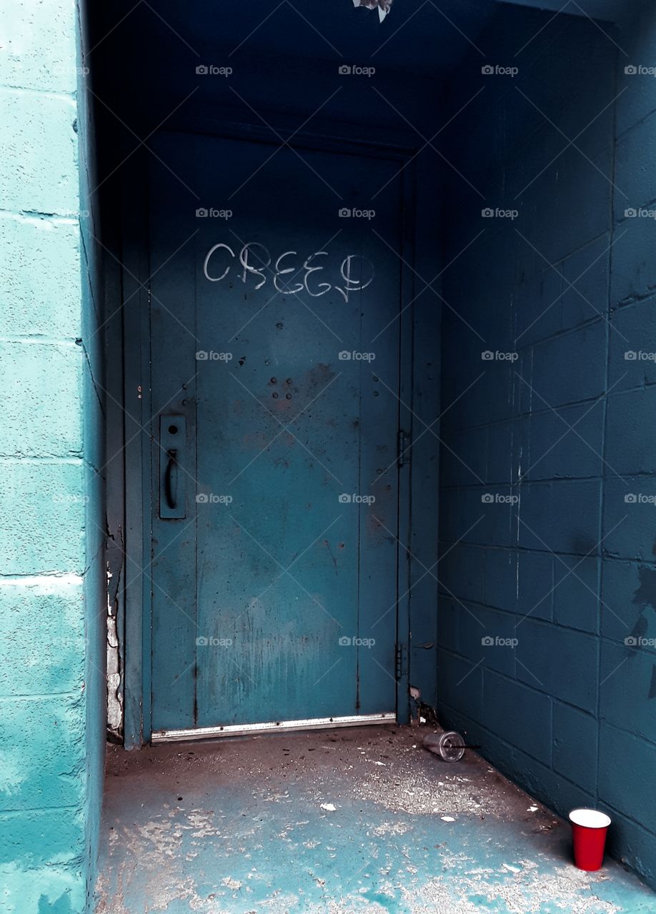 Doorway with graffiti and red cup