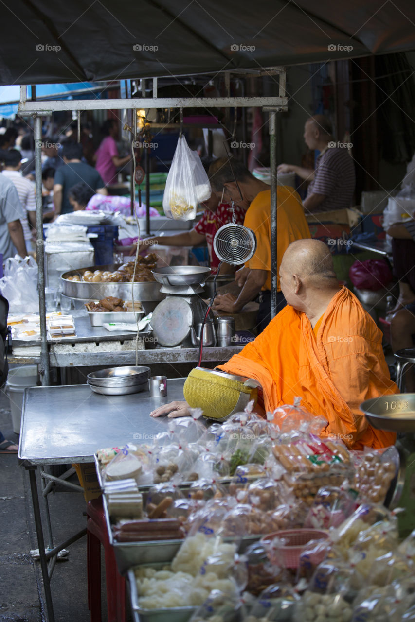 Monk at Market. Travelling through Bangkok I discovered this monk selling goods to raise funds for his temple.