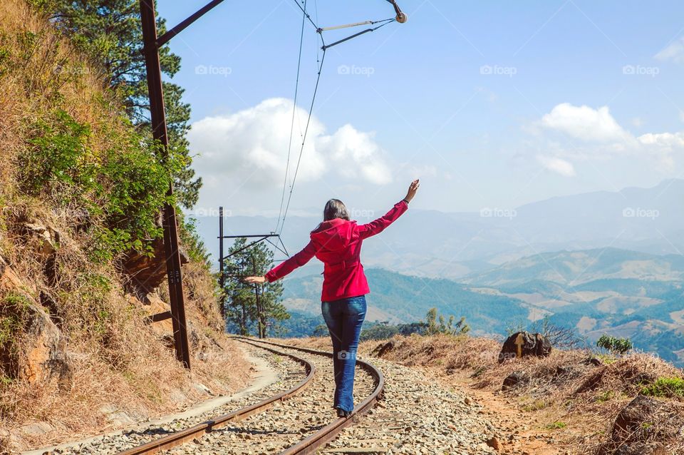 woman walking on train tracks in the mountains