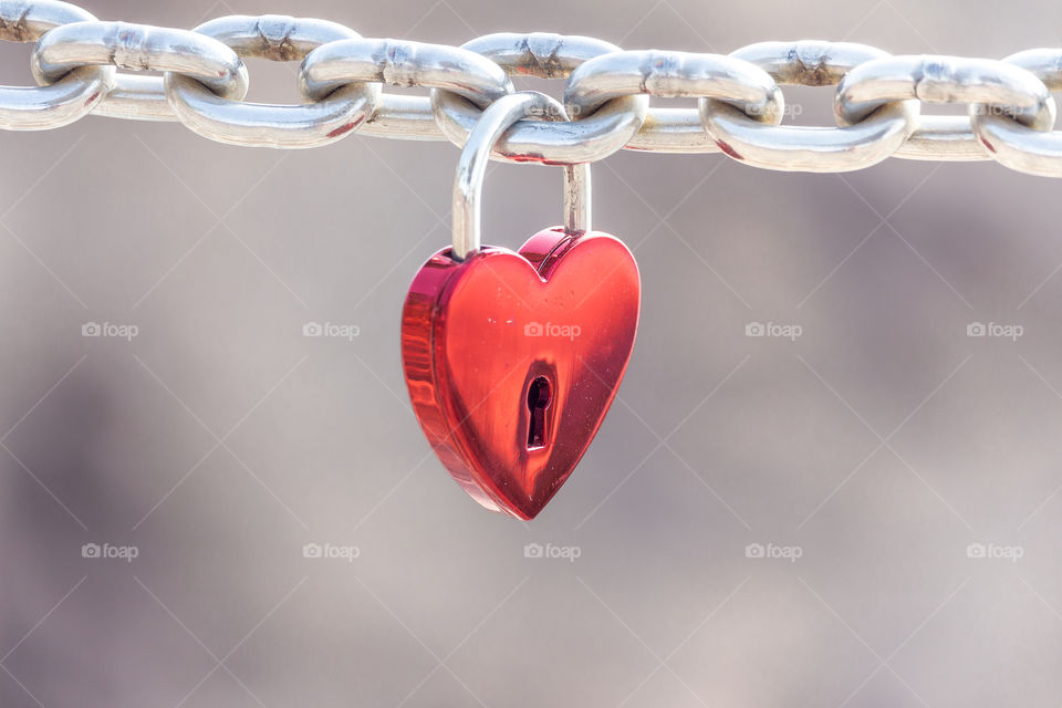 Beautiful red heart padlock on steel chain