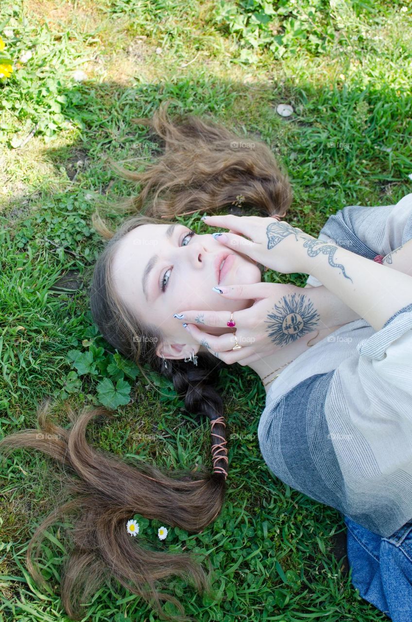 Portrait of Young Girl on Background of Daisies