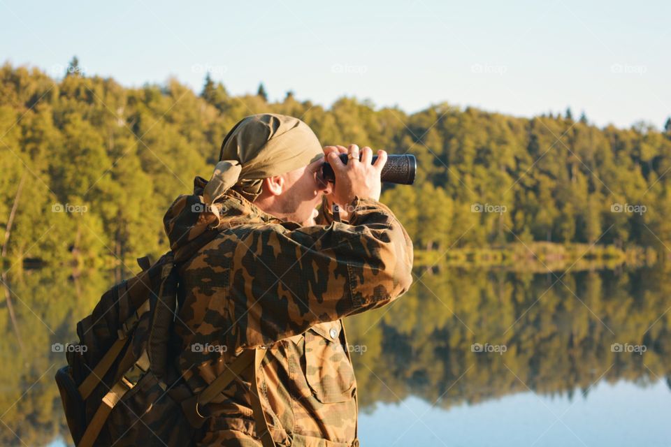 A man looks through binoculars