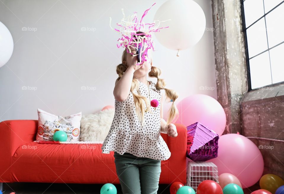 Blonde Girl Blowing Party Horn & Balloons