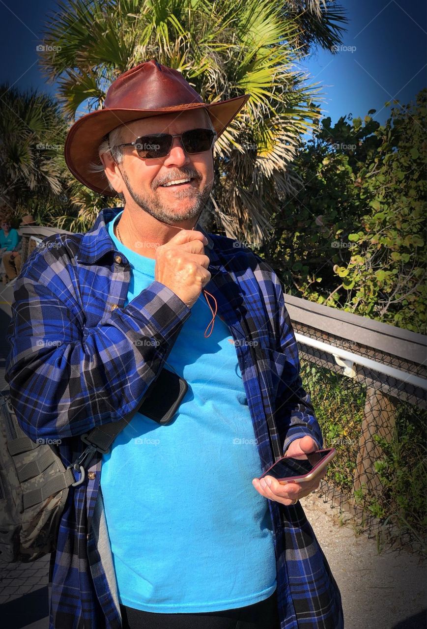 Handsome man adjusting his sun hat.