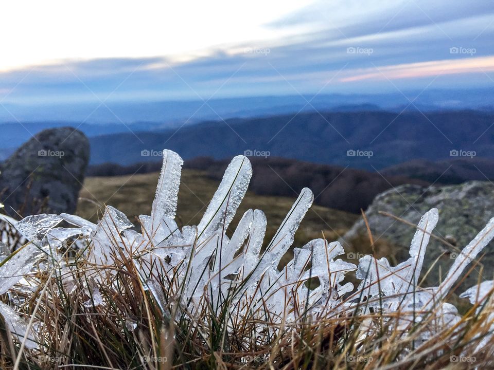 Frozen grass at the base of a mountainous scenery 