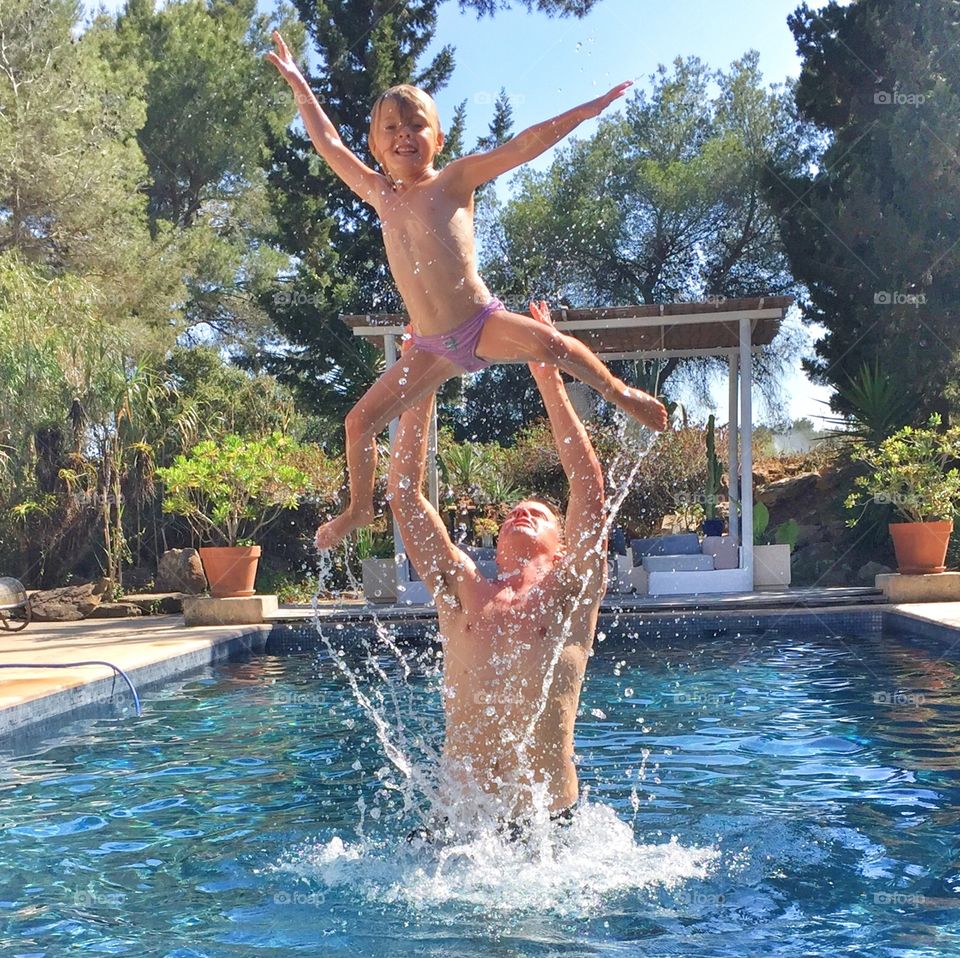 Father and daughter having fun in the pool