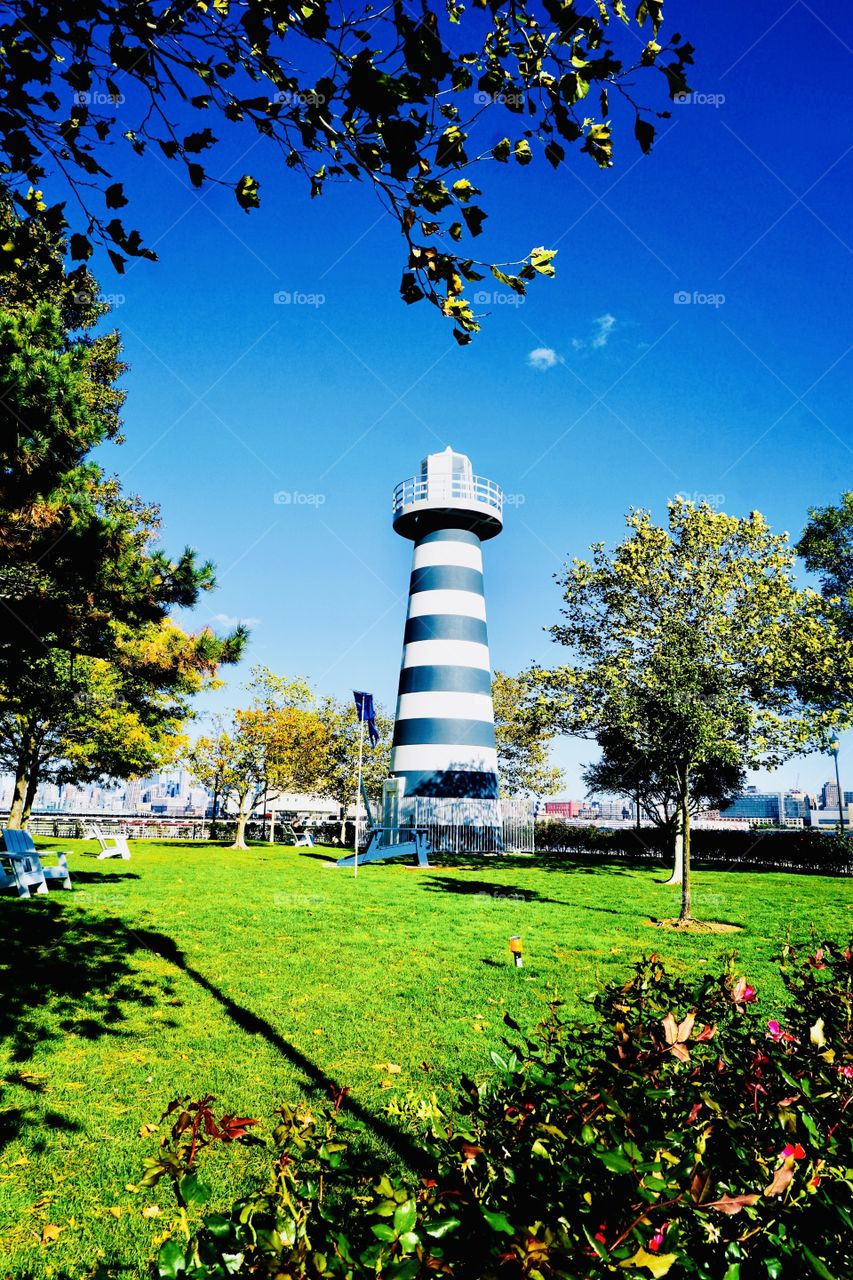 Sitting Garden-Faux lighthouse tower adds a nautical  ambiance to this garden by the river. 