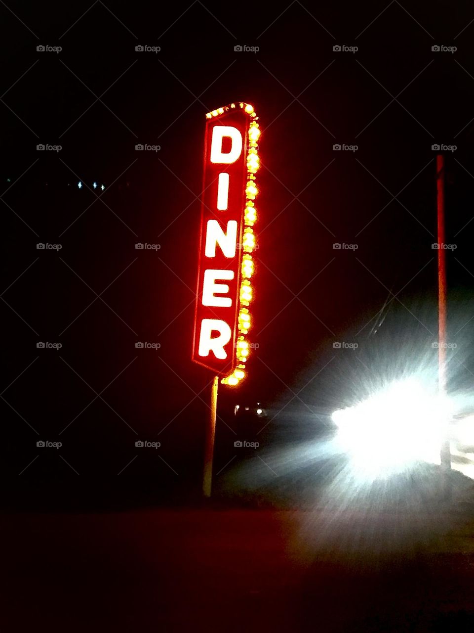 A vintage diner sign glows in the night as cars drive-by on Lincoln Highway, Lancaster county, Pennsylvania. This welcome sign, draws, tourists, locals, as well as truck drivers for a hot meal and cozy atmosphere.