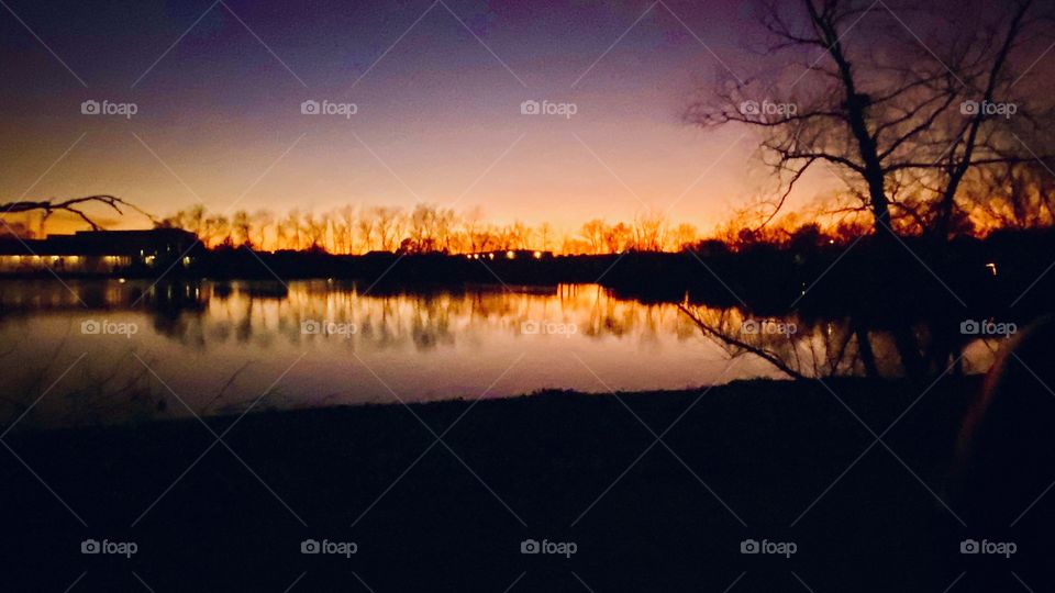 Silhouette Evening. Peaceful Surroundings. Beautiful Colors. Clear Atmosphere. Major Reflections on Lake Waters. 