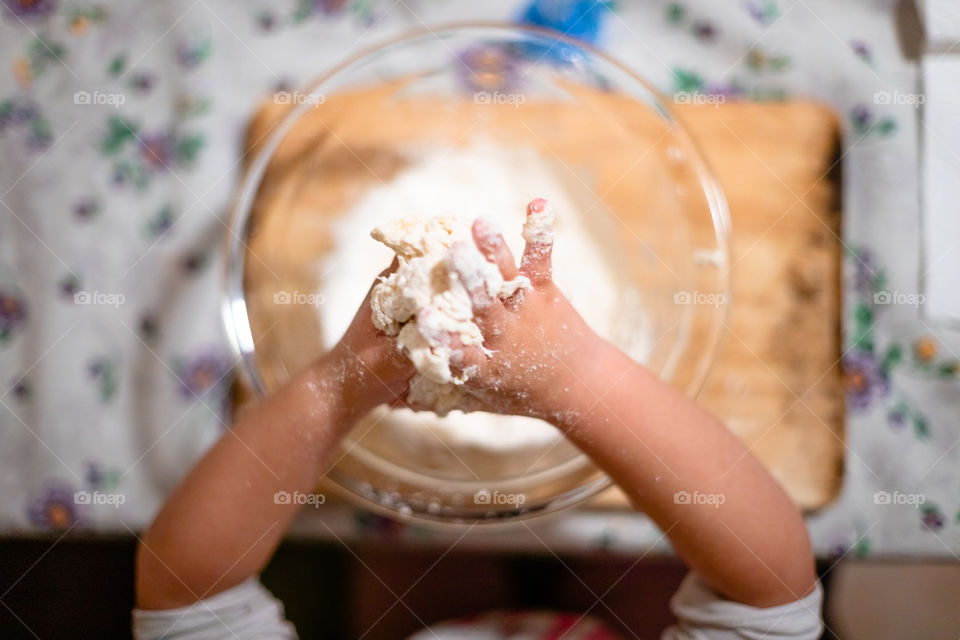 Child while playing with pasta and flour during the quarantine from Covid-19