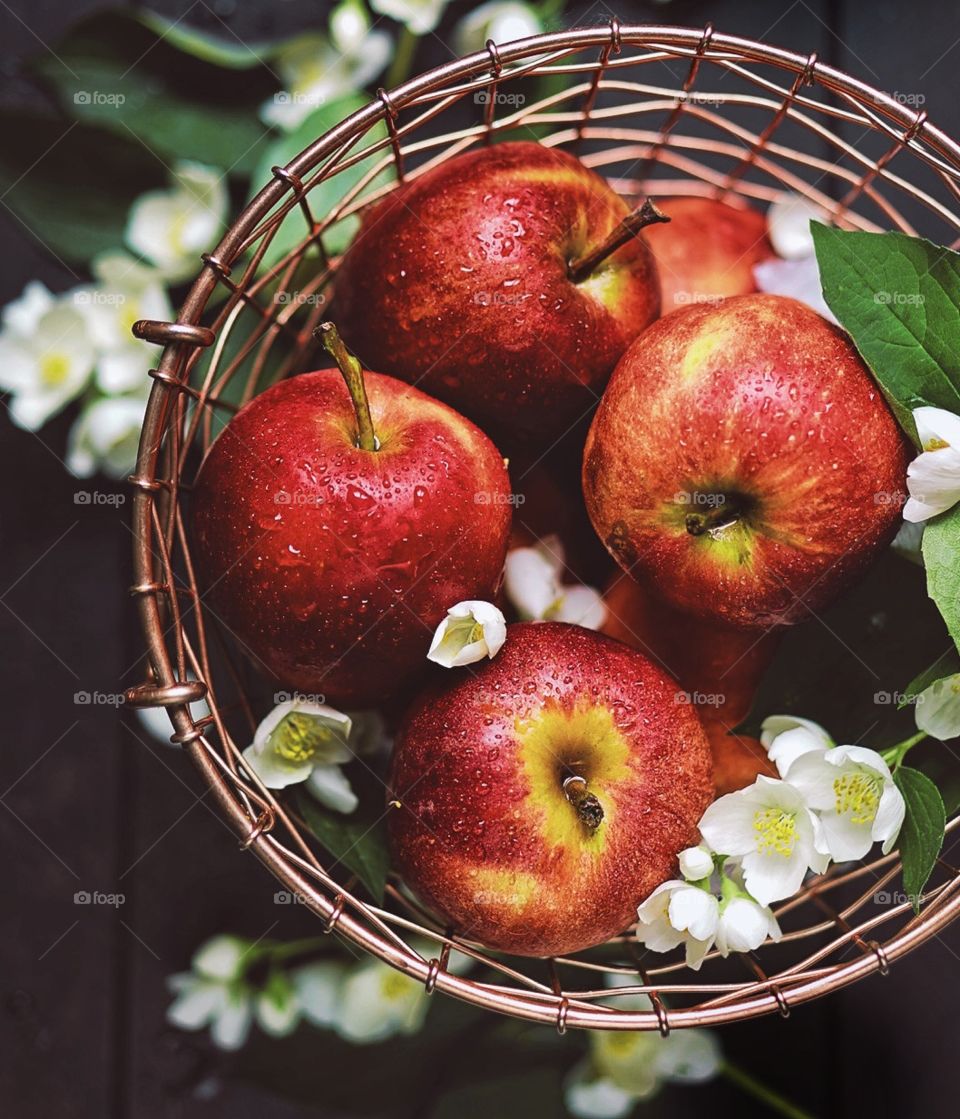 basket full of red apples and white flowers