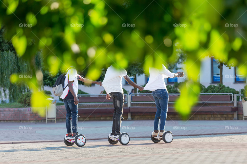 Three friends riding gyro scooters together, having fun