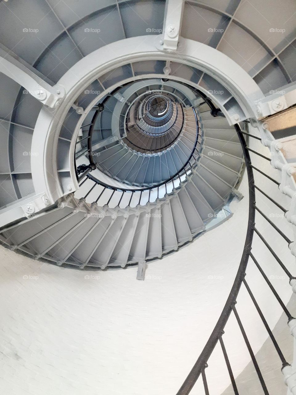 A photo of the steep spiral staircase of the Ponce Inlet Lighthouse in Ponce Inlet, Florida taken from below.