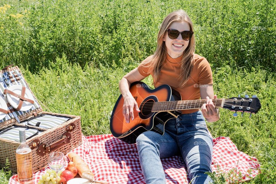 woman playing guitar on picnic