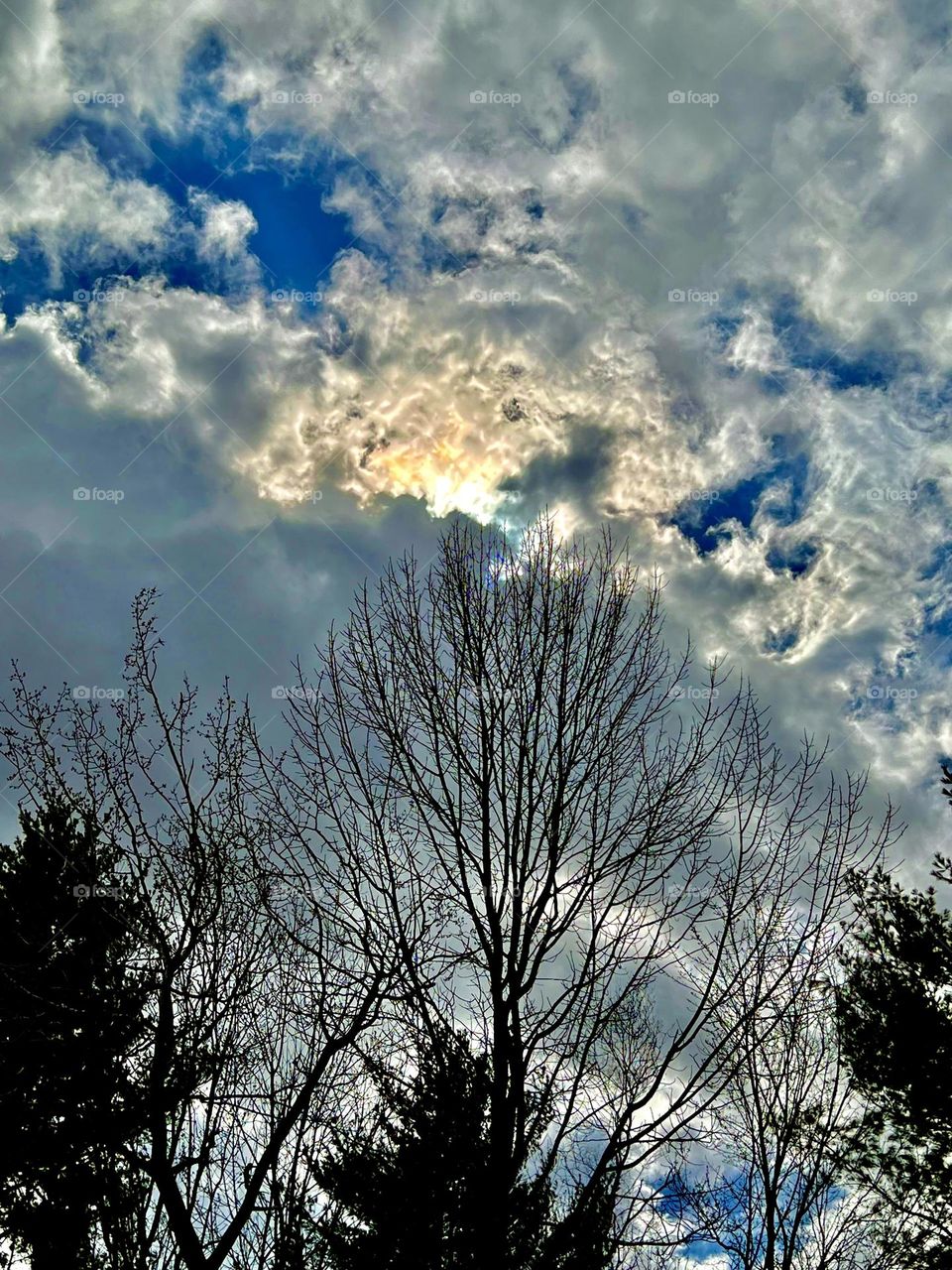 The sun peaking over storm clouds in spring.