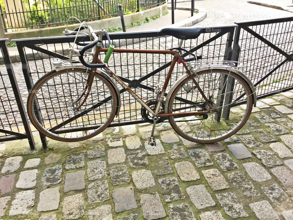 Cycling Week: Do you love your bicycle? A bicycle is securely locked leaning up against the bicycle rack