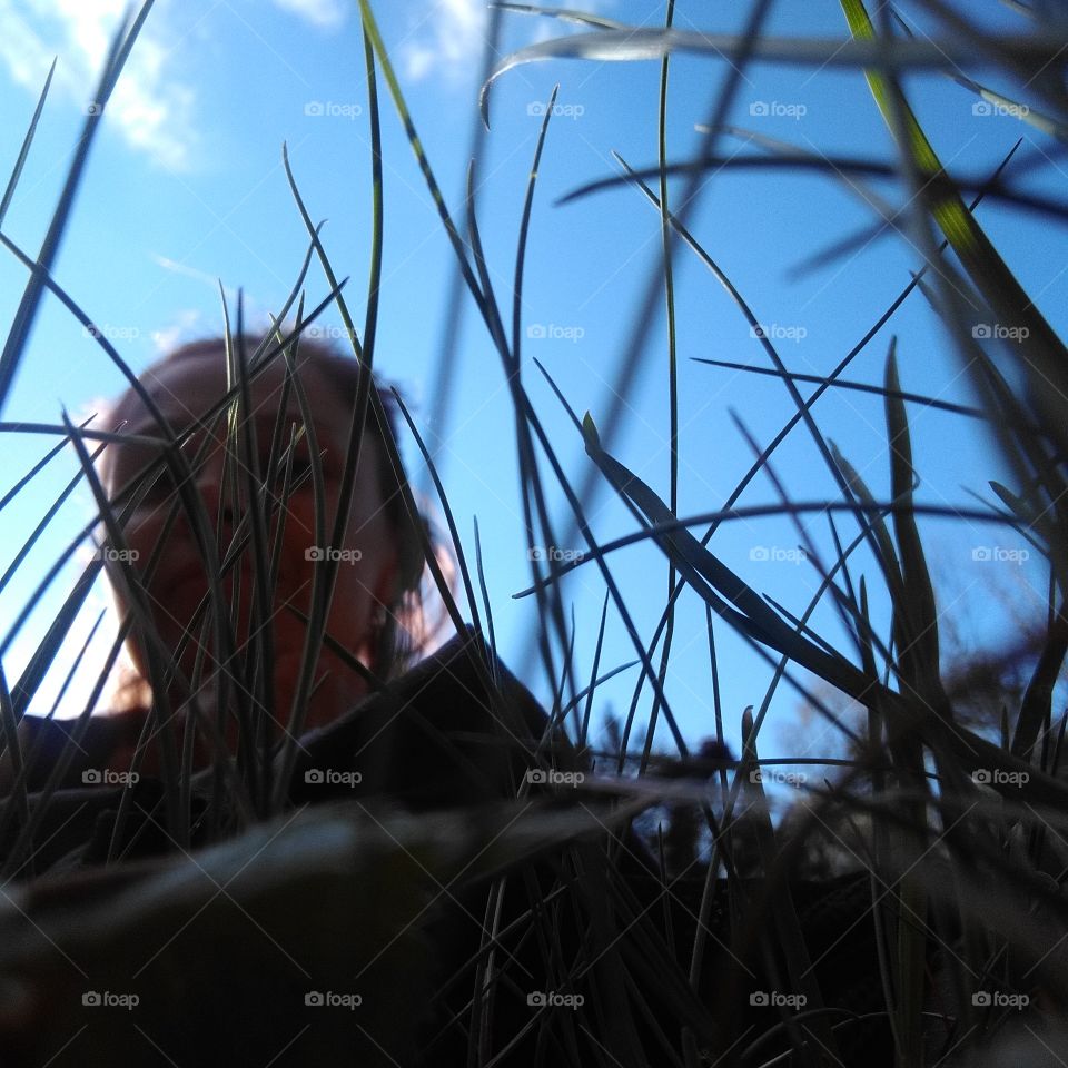 girl view in green grass blue sky background