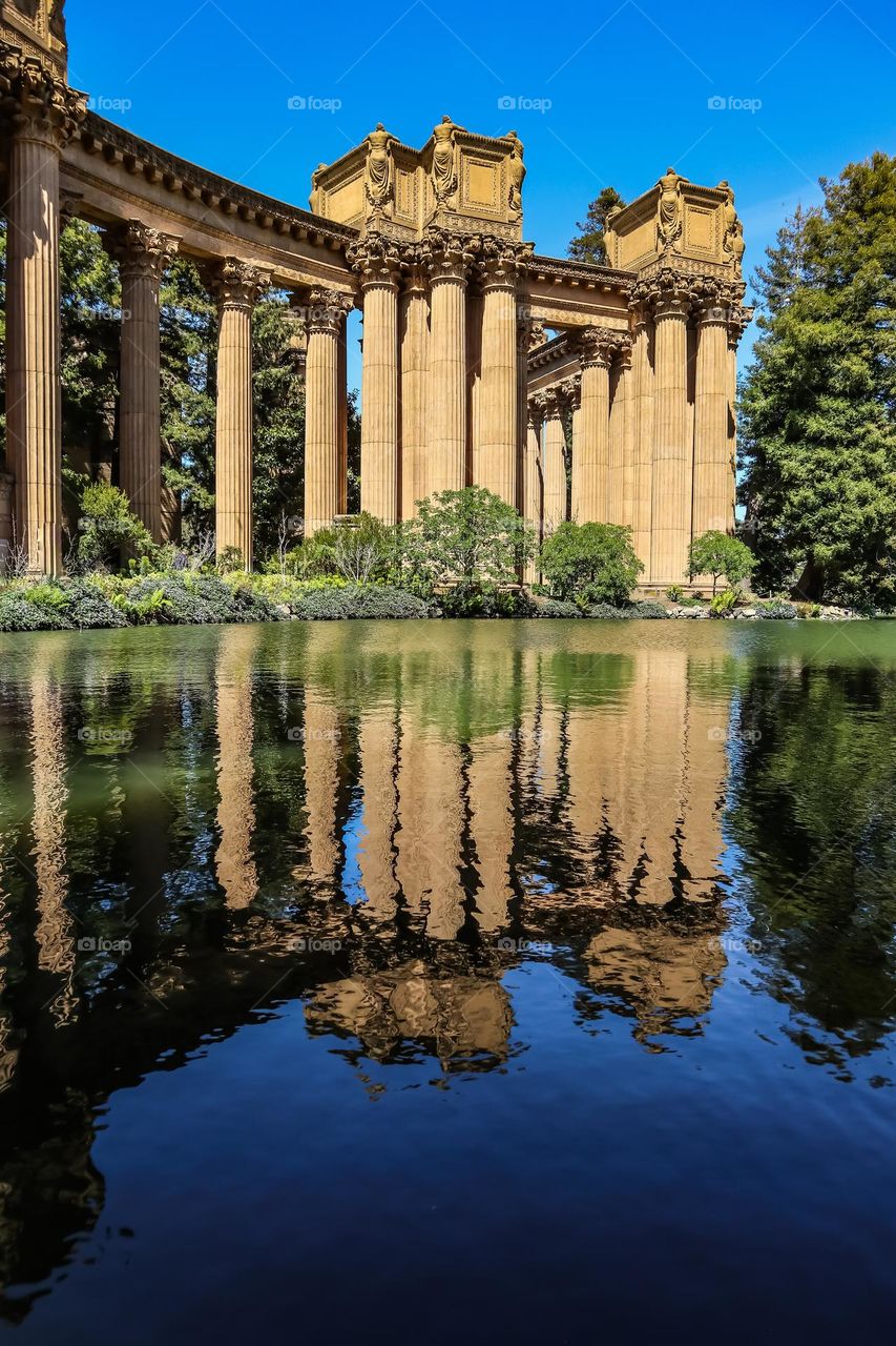 Columns of the palace of fine arts in San Francisco California reflecting in the lagoon on a warm spring day