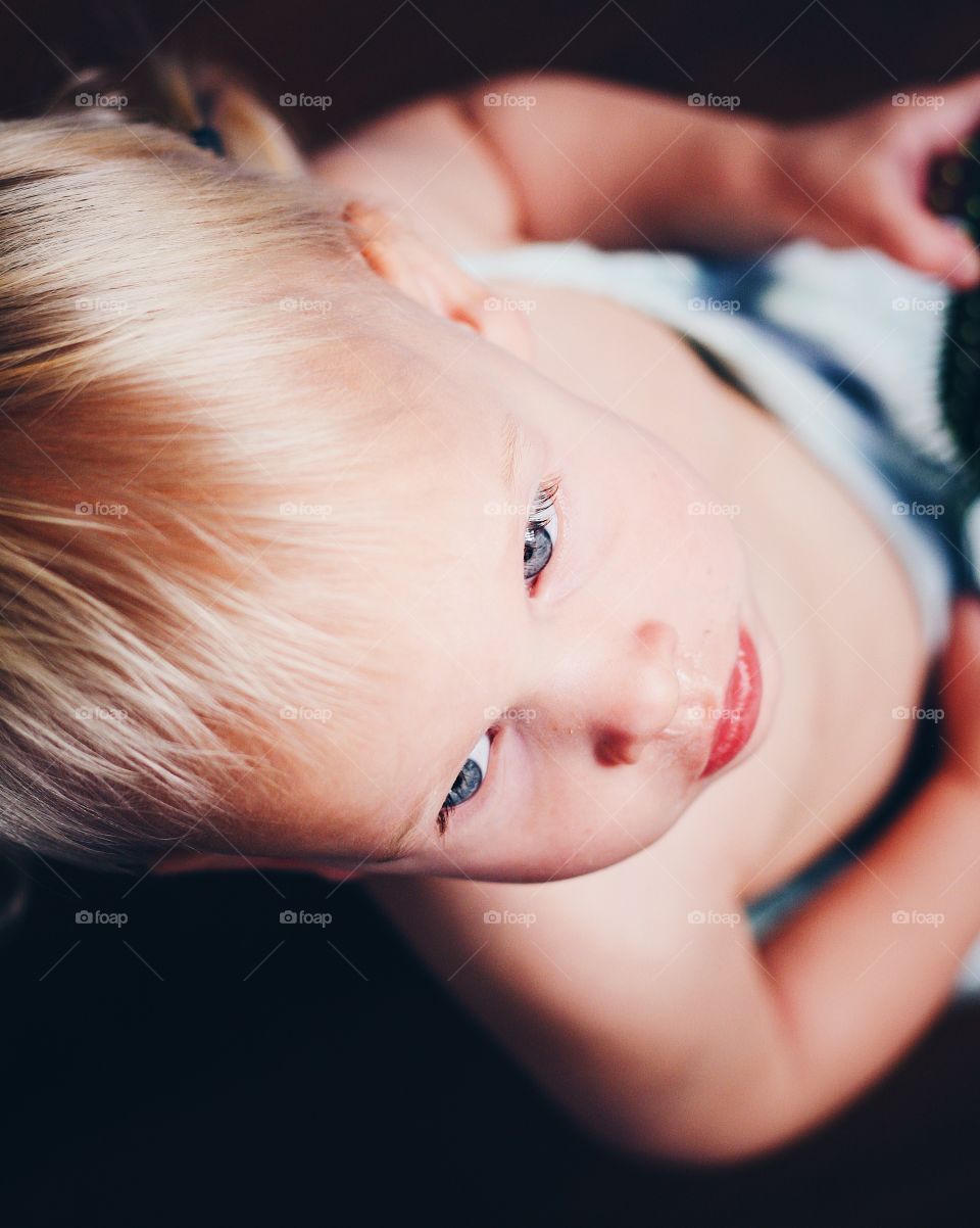 Dramatic picture of baby girl with blond hair staring in the distance with bright blue eyes