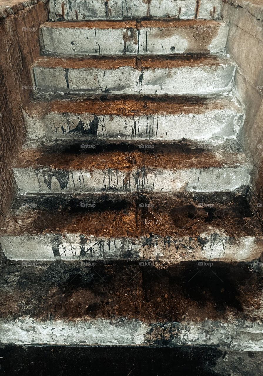 Close-up of an old stony stair with dirt and dabs of paint on its steps