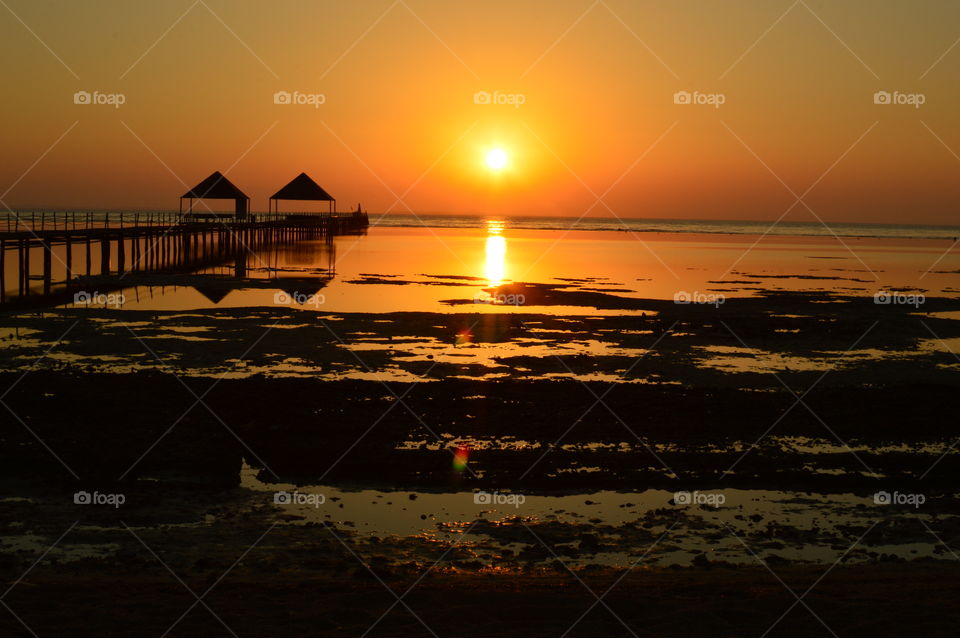 silhouette of a pier in the middle of the sea