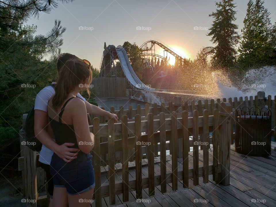 Water park ride at sunset teen couple
